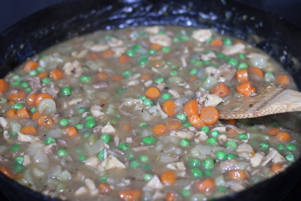 Chicken Pot Pie base cooking in cast iron pan. 
