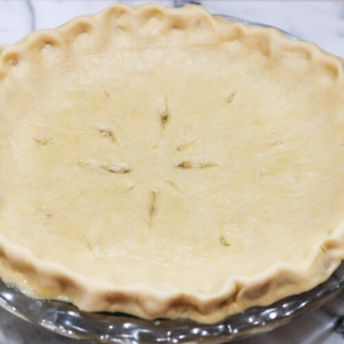 Pie with raw crust on top. Slits cut in top for venting.