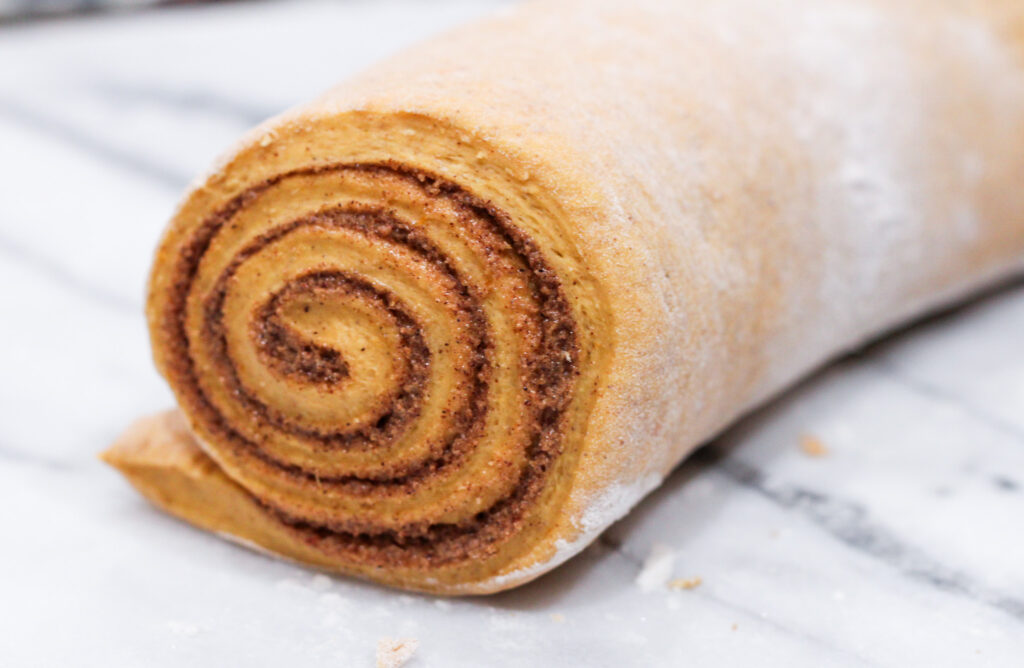 Pumpkin Cinnamon roll assembled and rolled up but not cut. 