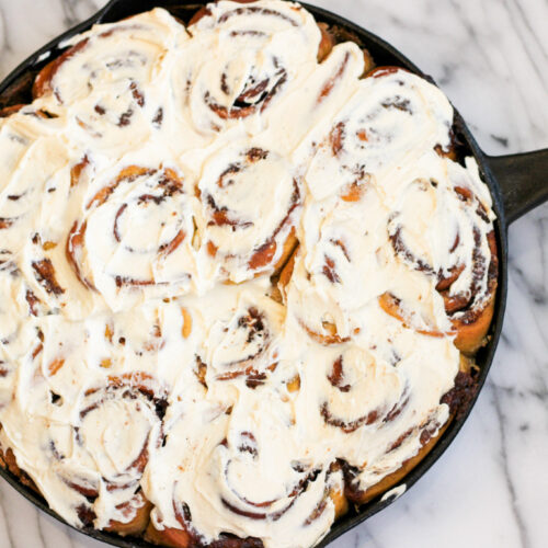 Baked and frosted Pumpkin Spice Cinnamon Rolls in Cast Iron Pan. #castironcooking #pumpkinspice #autumncooking