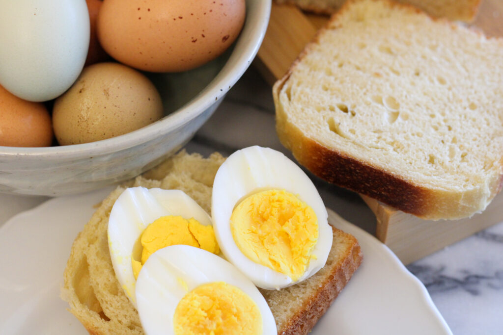 Boiled eggs sliced on piece of bread. 