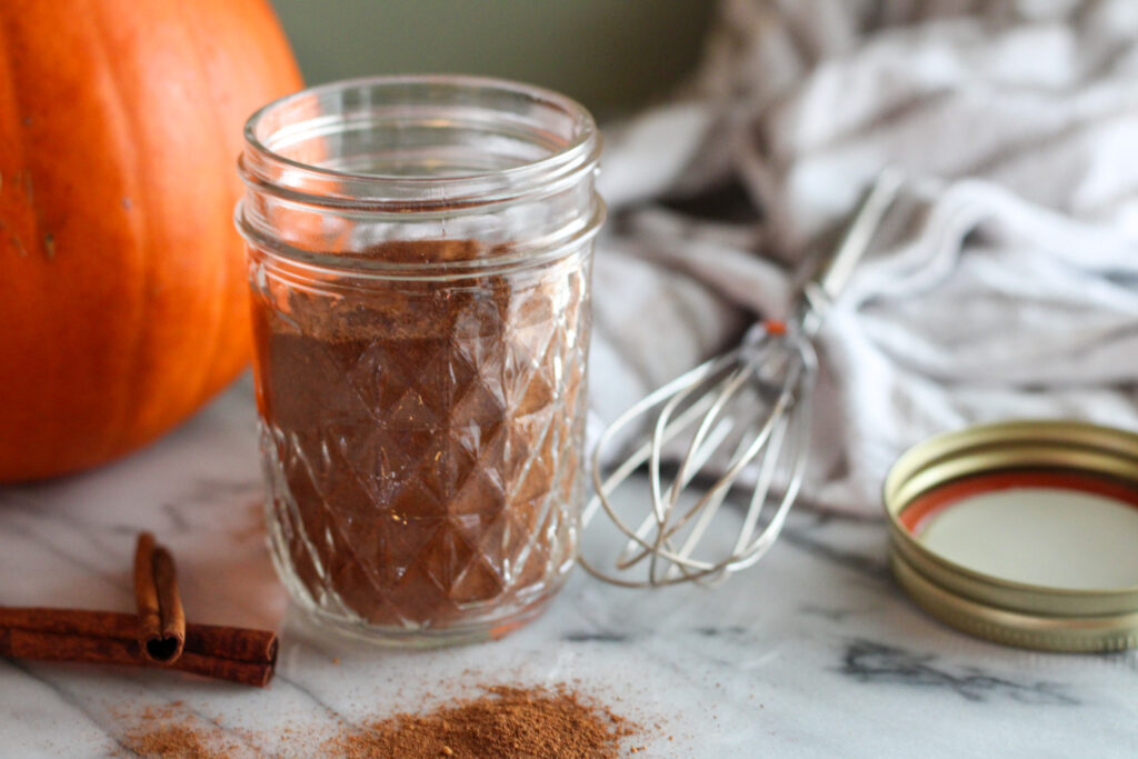 Pumpkin pie spice in glass jar with lid off.