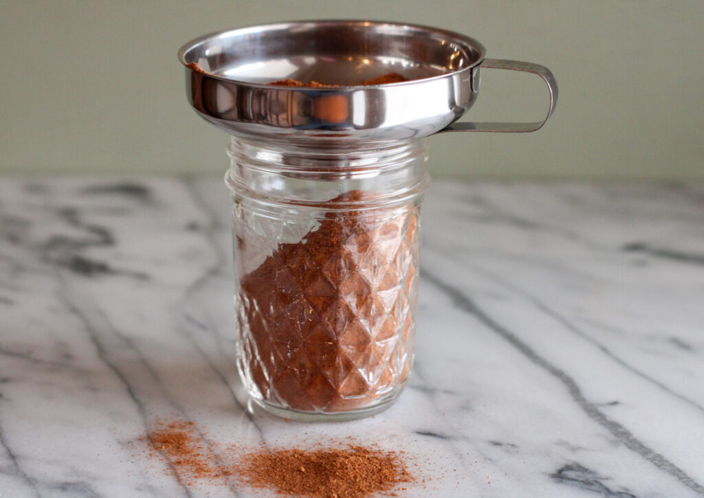 Pumpkin pie spice in jar with canning funnel.