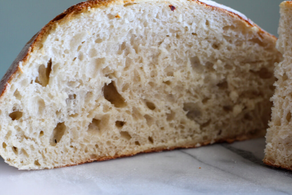 Sourdough loaf sliced to expose center.