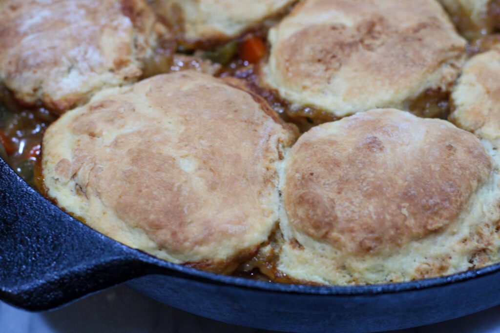 Cooked Chicken and Biscuits in a cast iron pan. 