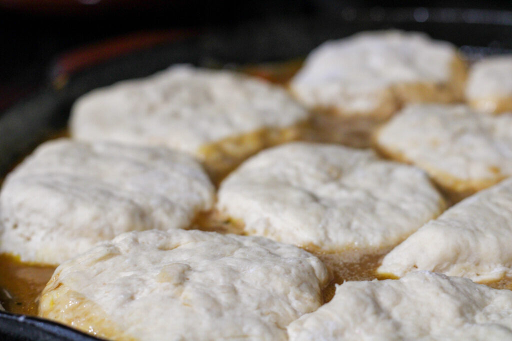 Uncooked chicken and biscuits in cast iron pan