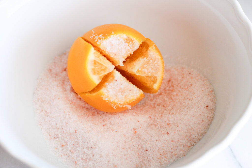 Quartered lemon with tip removed in bowl of pink salt.
