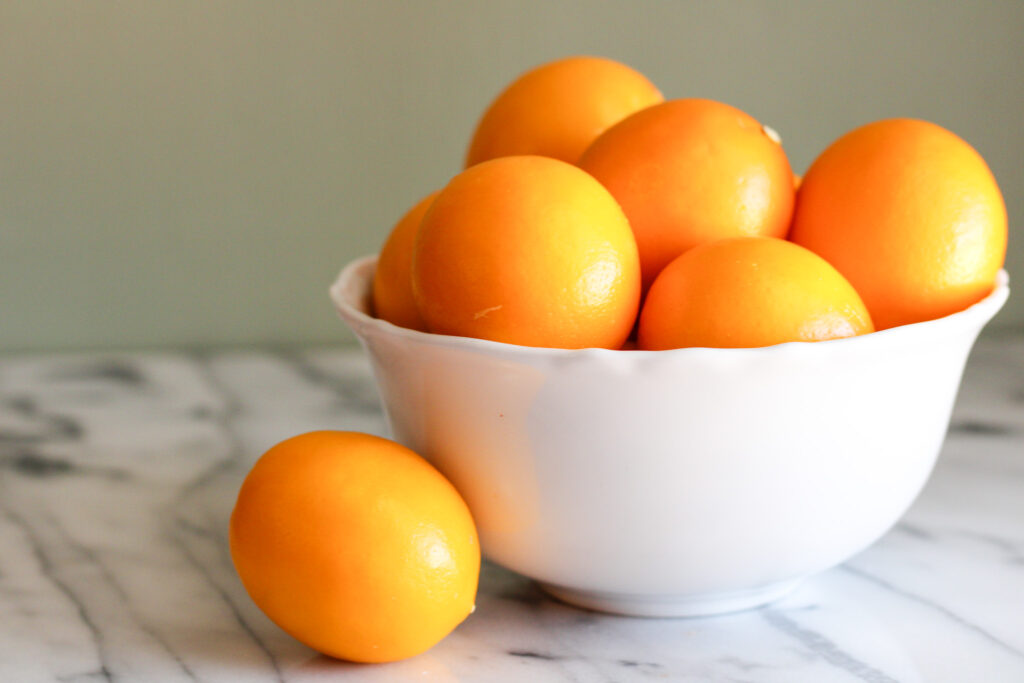 White bowl full of meyer lemons.