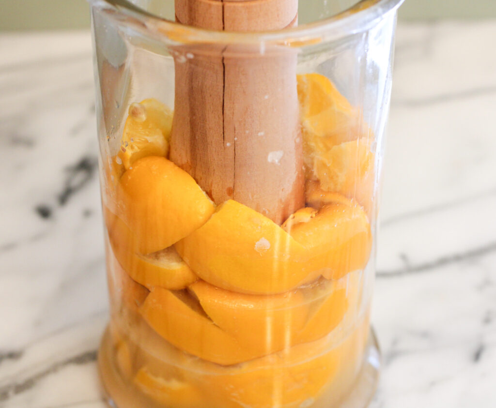 Pressing the juice out of lemons in a glass jar.