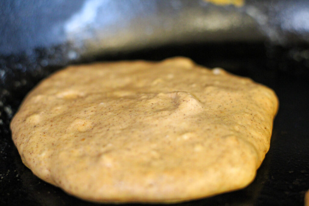 Pumpkin Pancake batter cooking on griddle.