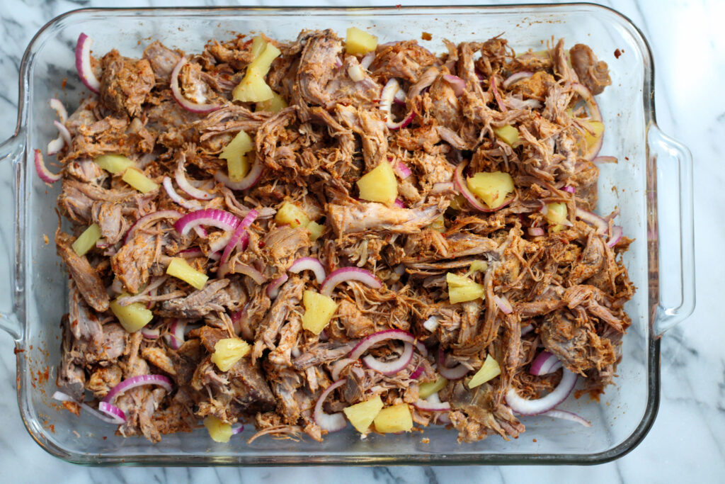 Tacos al pastor meat in glass casserole dish.