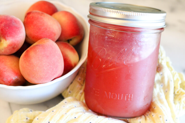 Bowl of peaches, jar of peach jam.