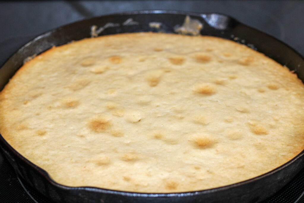 Cooked peach upside down cake in cast iron pan
