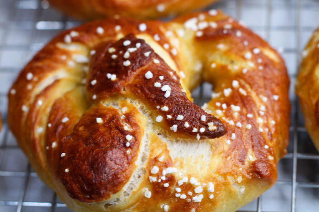 Close up of sourdough soft pretzels on cooling rack.