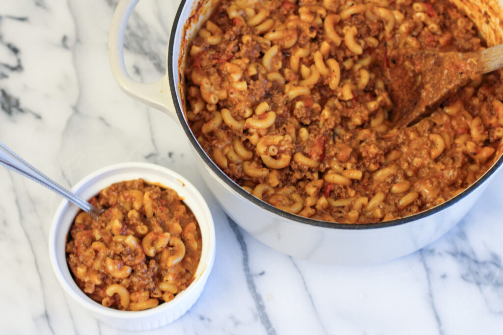 Homemade hamburger helper in large pot and individual bowl.