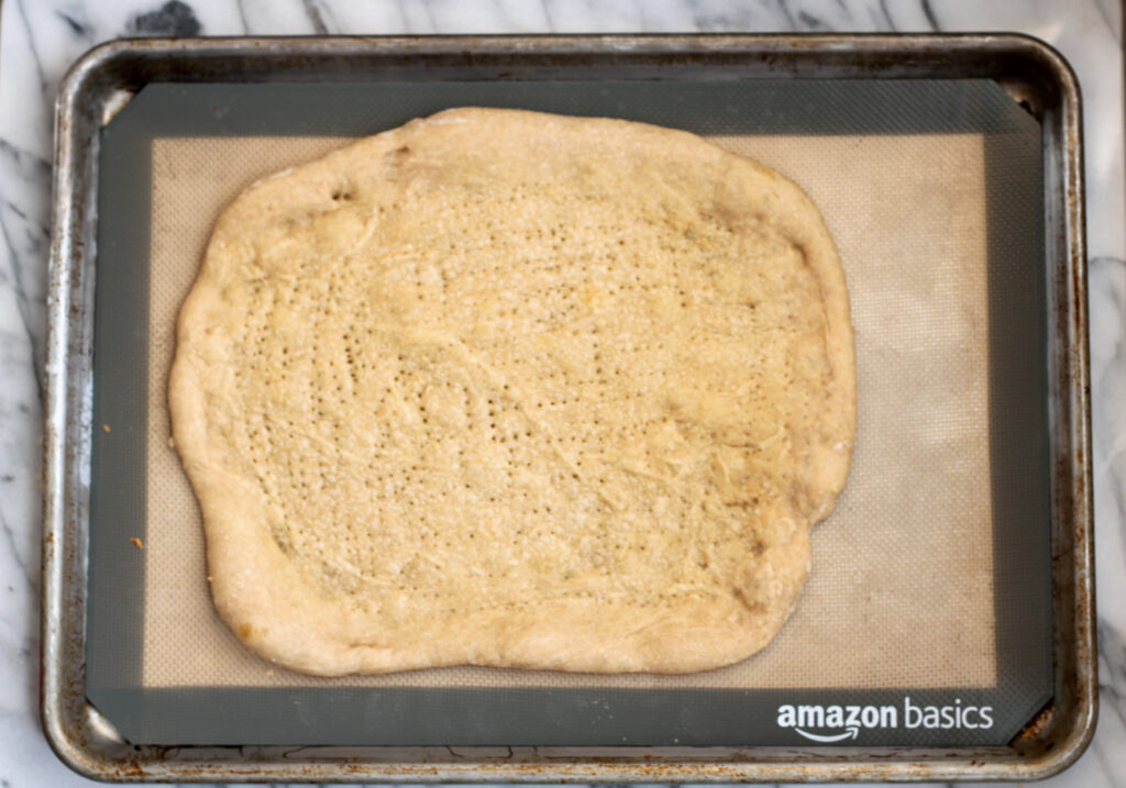 Par-baked pizza crust on baking sheet. 