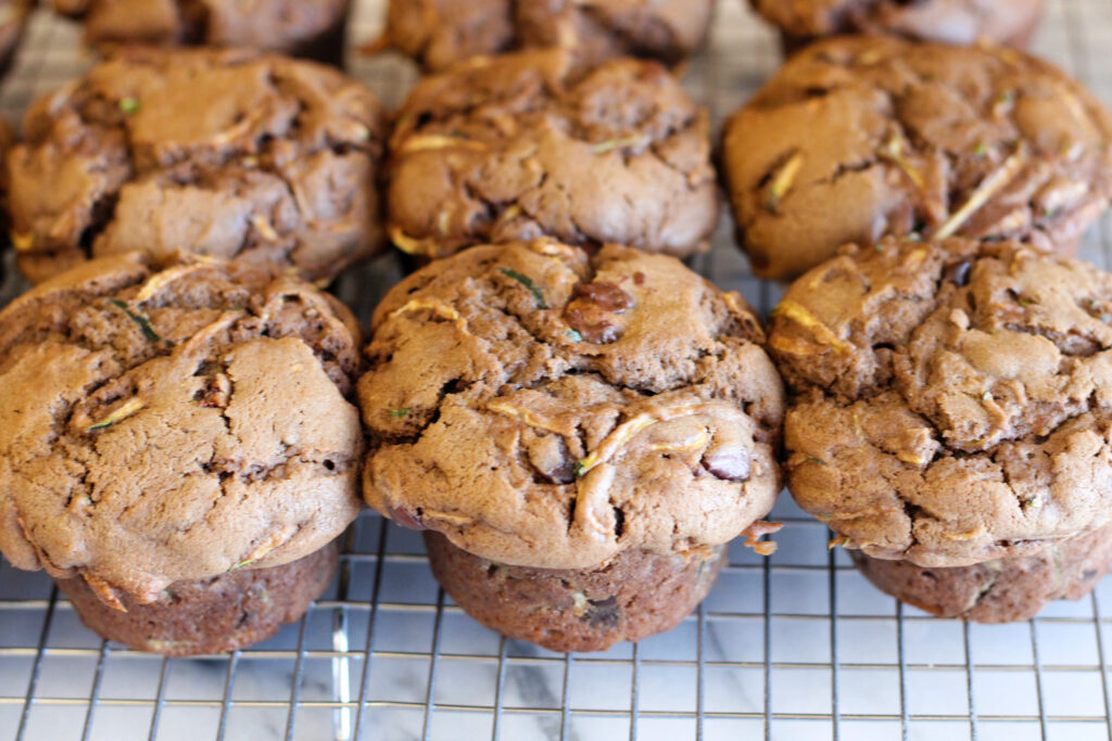Sourdough chocolate chip zucchini muffins on cooling rack.