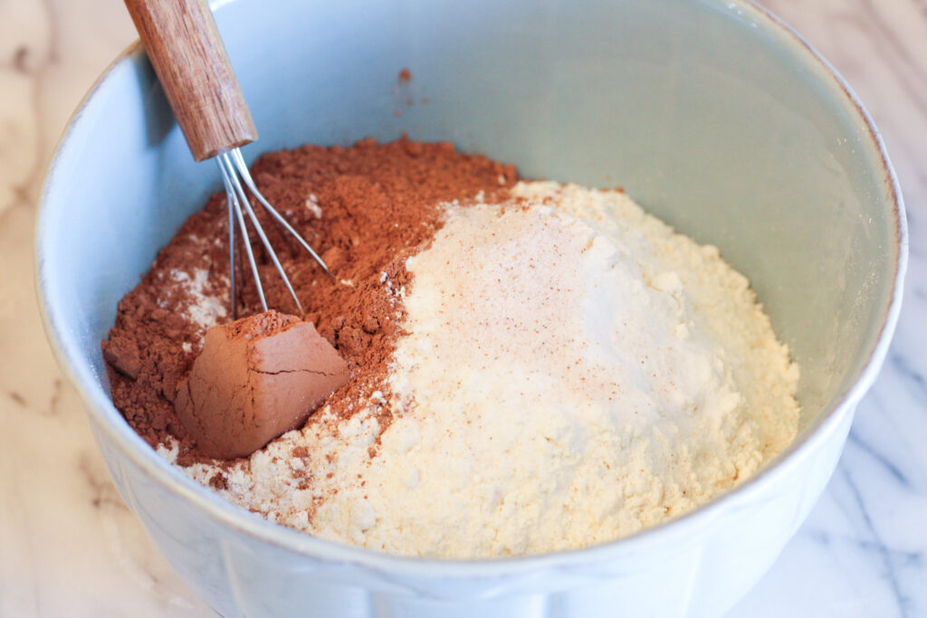 Blue bowl with powdered ingredients including flour and coco powder.