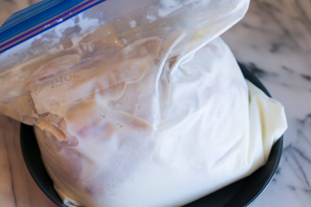 Ziplock bag with whole chicken brining in buttermilk.