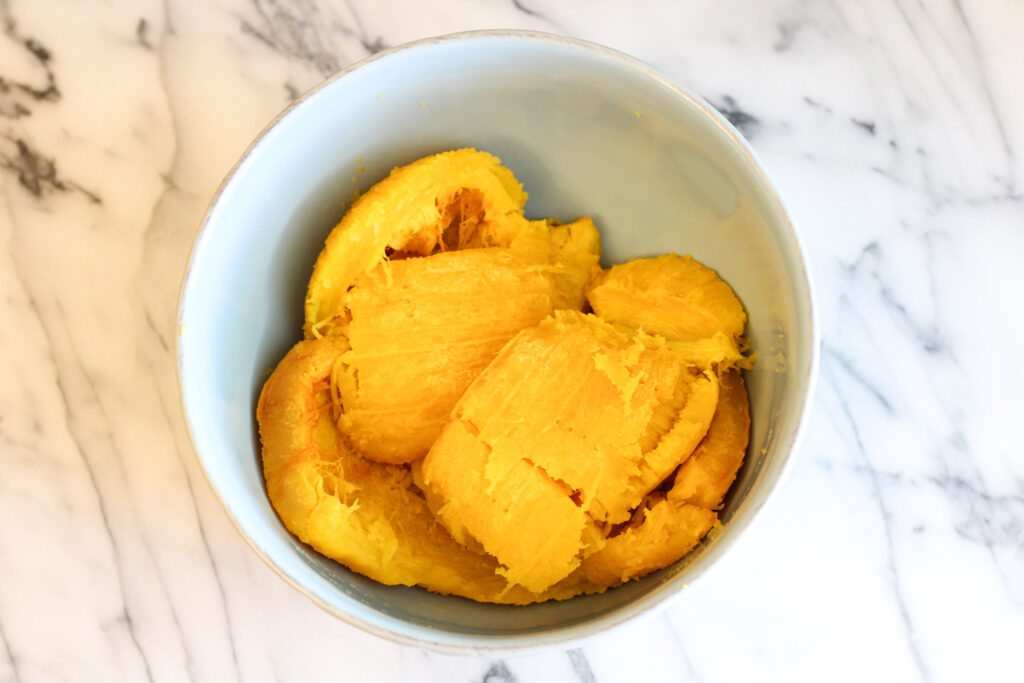 Bowl of roasted pumpkin on countertop.