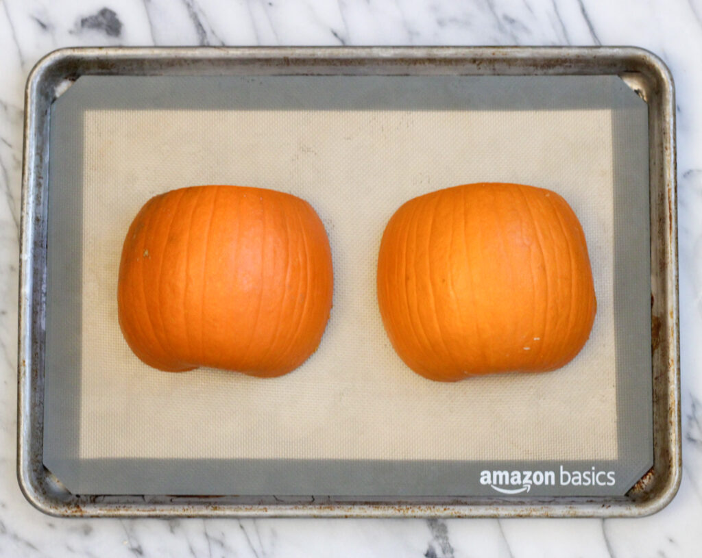 Pumpkin halves on baking sheet.