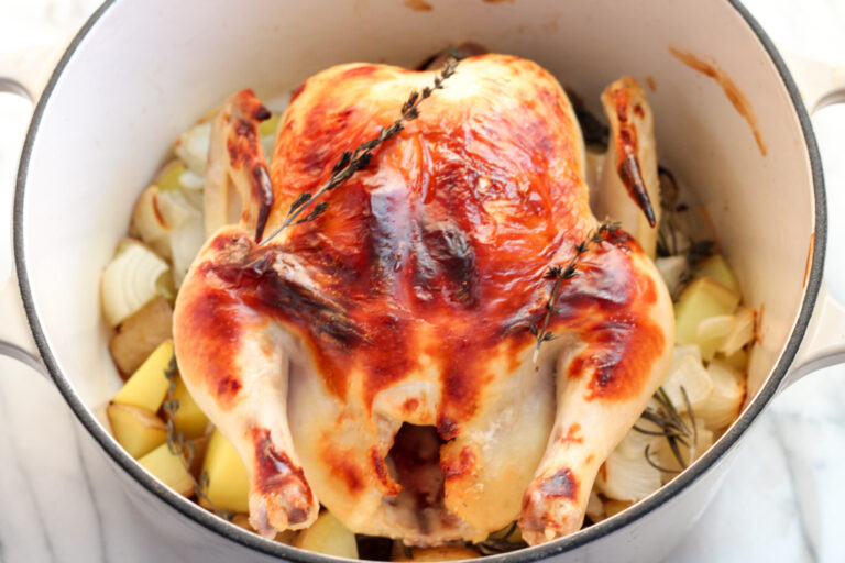 Roasted Chicken in dutch oven with potatoes and onions.