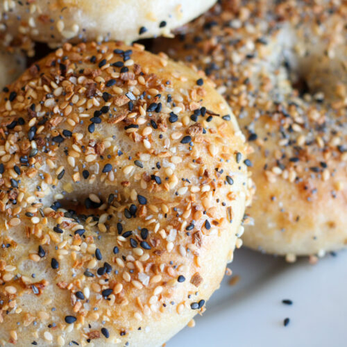 Closeup of Sourdough Everything Bagels on white plate.