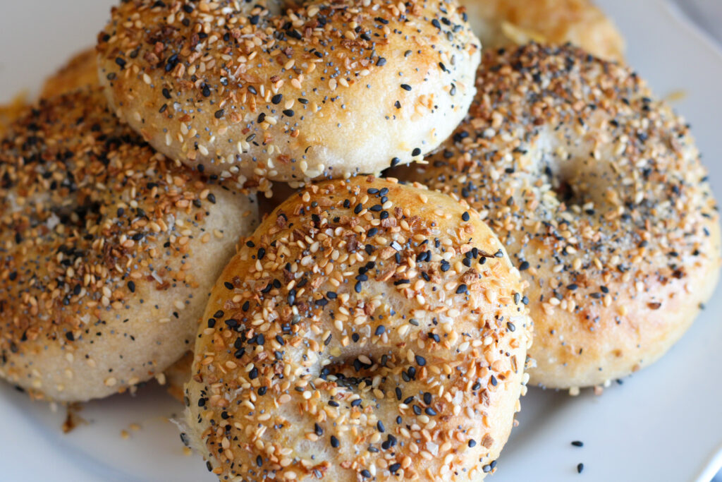 Closeup of Sourdough Everything Bagels on white plate.