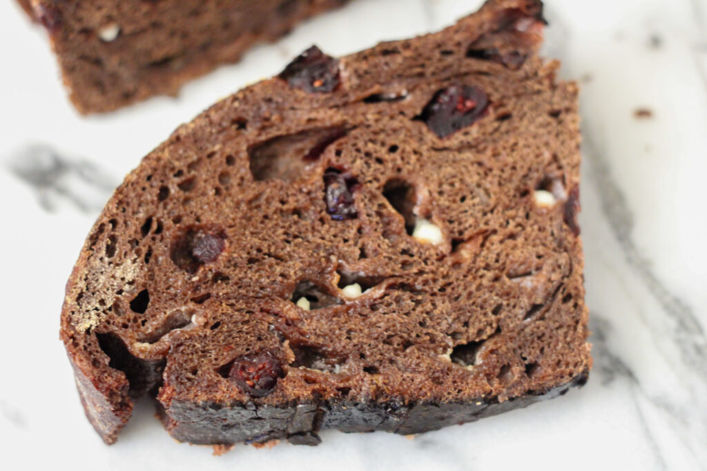Cut chocolate bread loaf with cranberries and white chocolate chips.