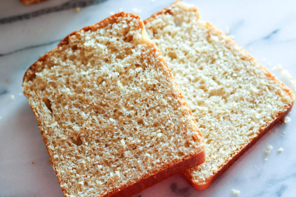 Two slices of sandwich bread on countertop. 