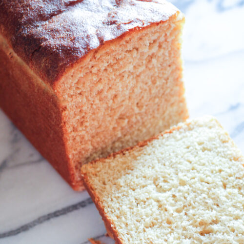 Loaf of fresh milled sandwich bread with slice removed.