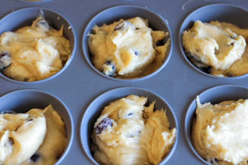 Blueberry muffin batter in muffin tin. 