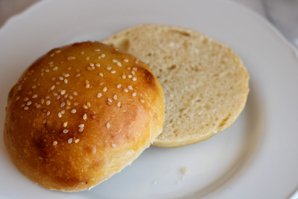 Sliced hamburger bun on plate.