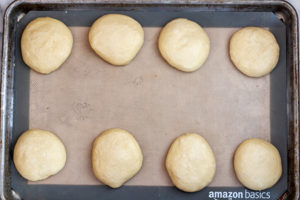 Shaped bun dough on baking sheet.
